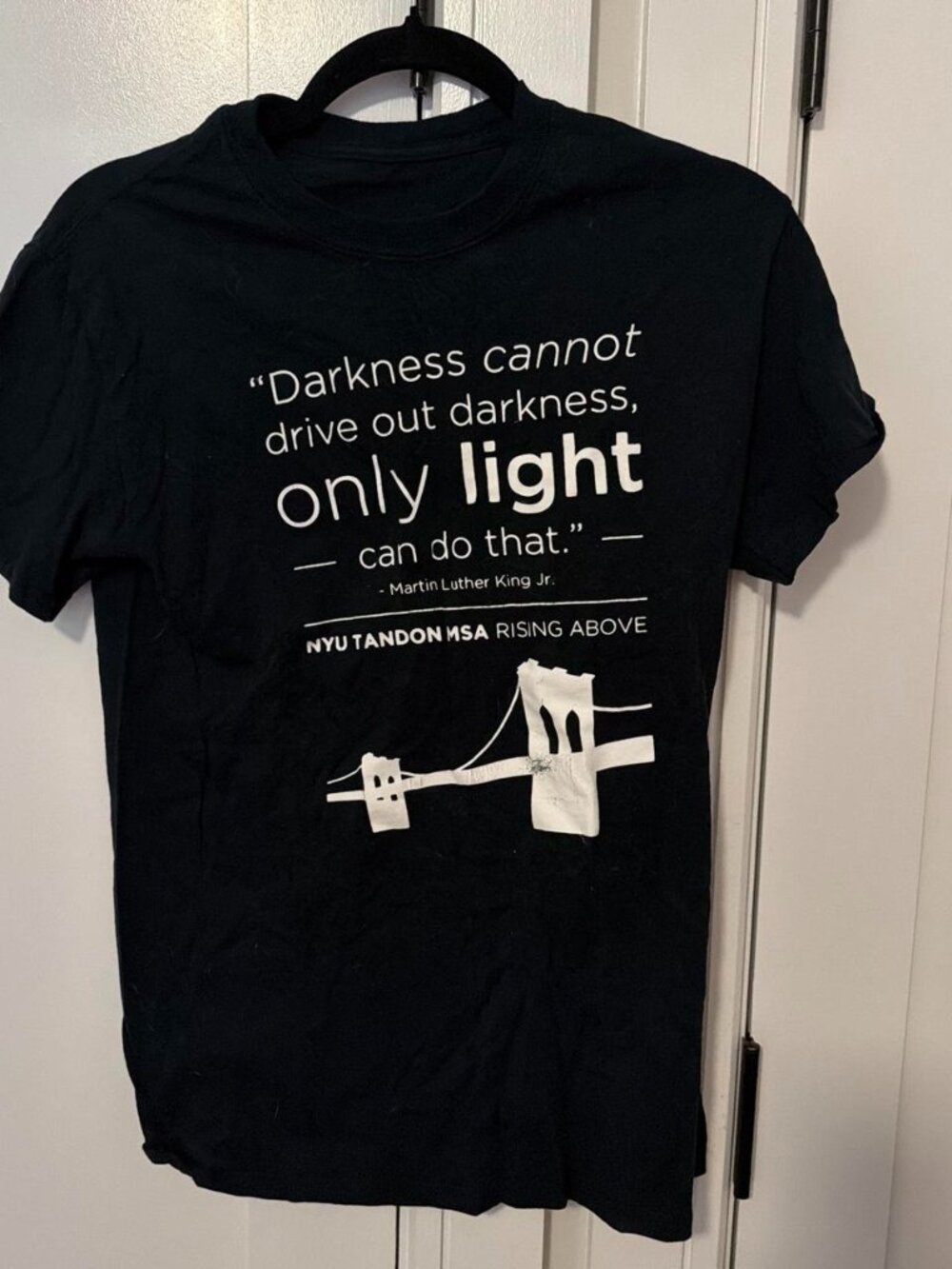 Black t-shirt with white MLK quote and bridge graphic
